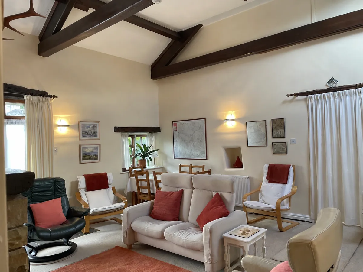 Sitting area with sofas and armchairs beneath dark exposed beams